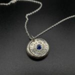 Médaillon à la façon d’une pièce ancienne, argent et saphir