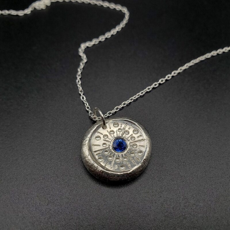 Médaillon à la façon d’une pièce ancienne, argent et saphir